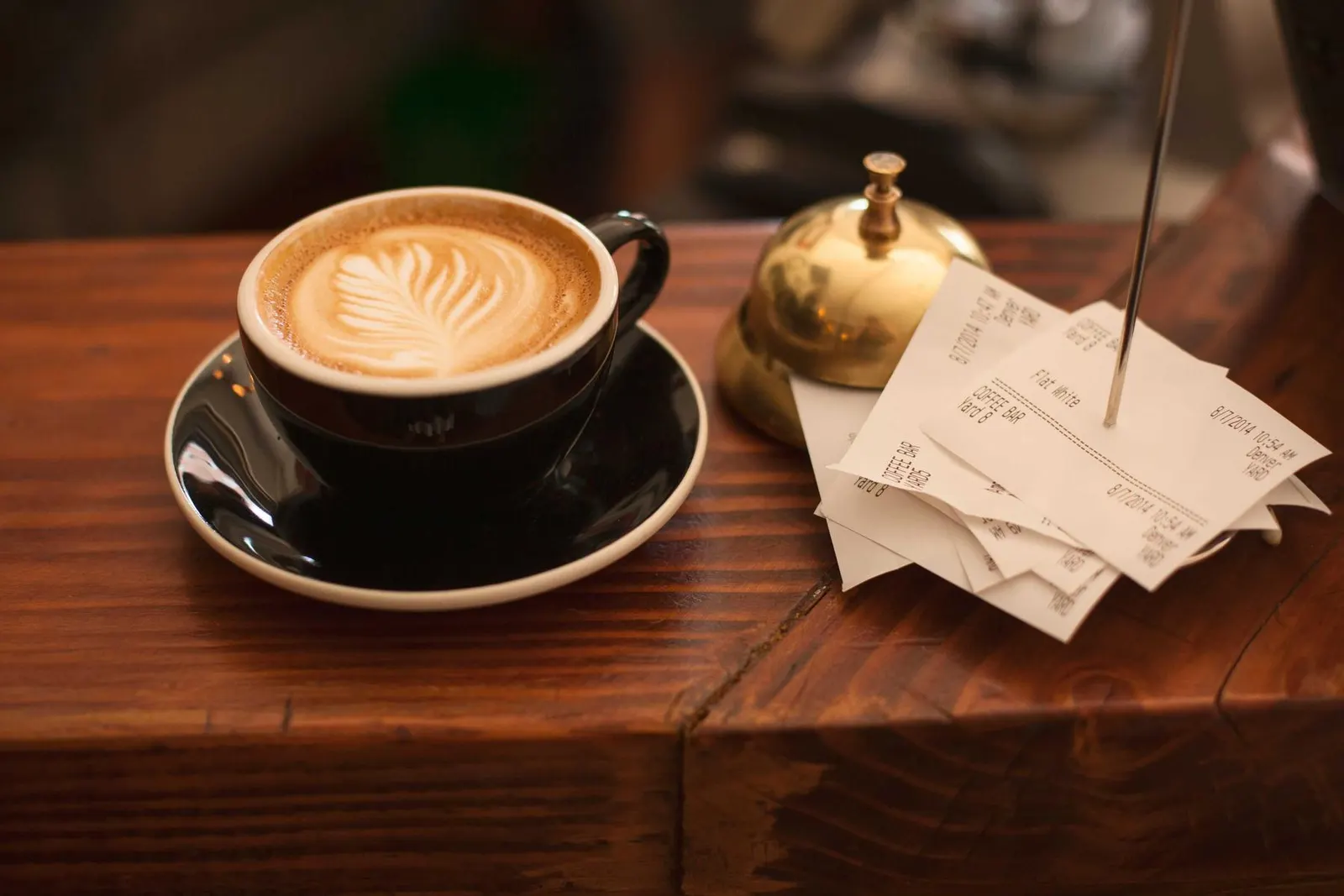 A latte with a leaf pattern on a wooden table