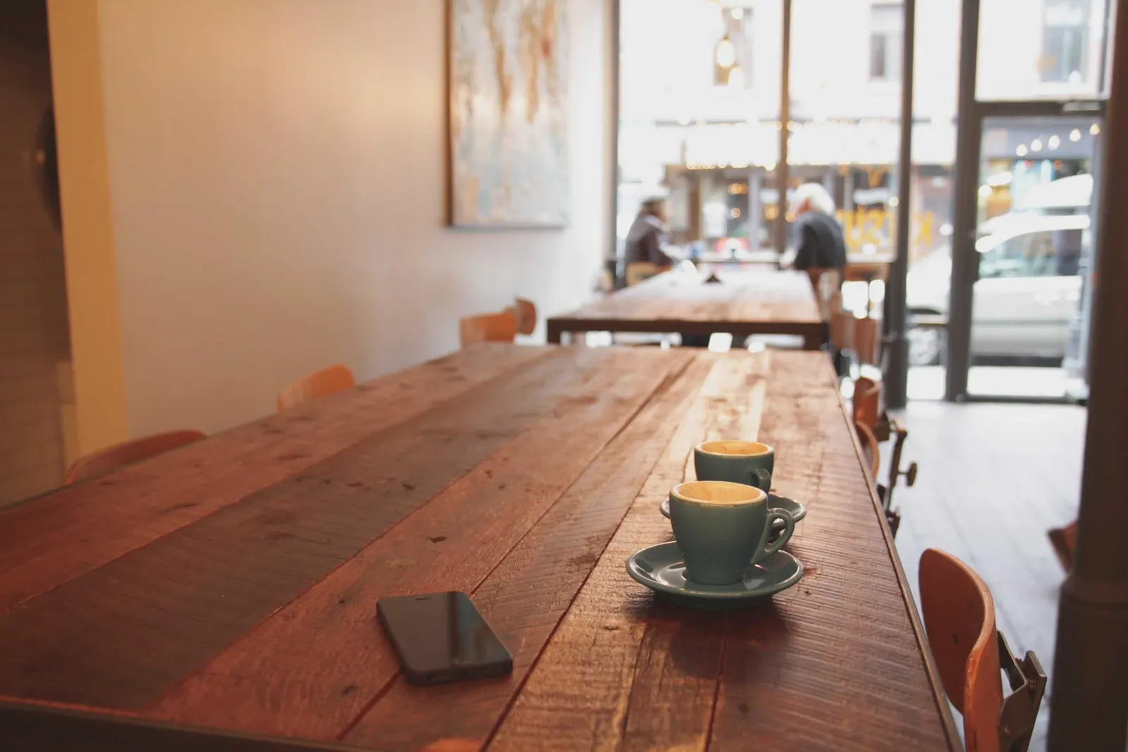 A bright cafe interior with long wooden tables