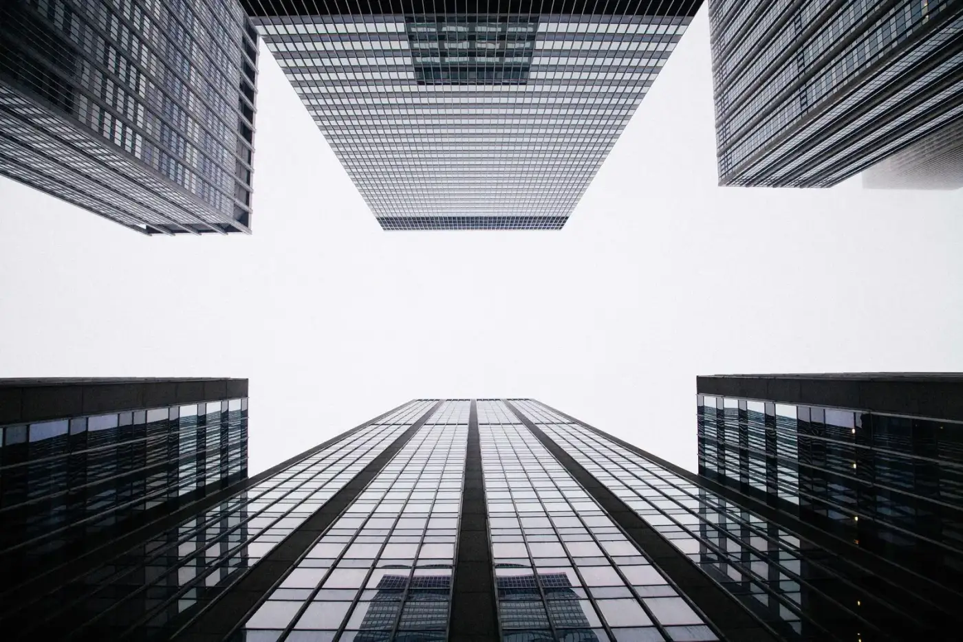 Glass towers seen from below, converging into the sky