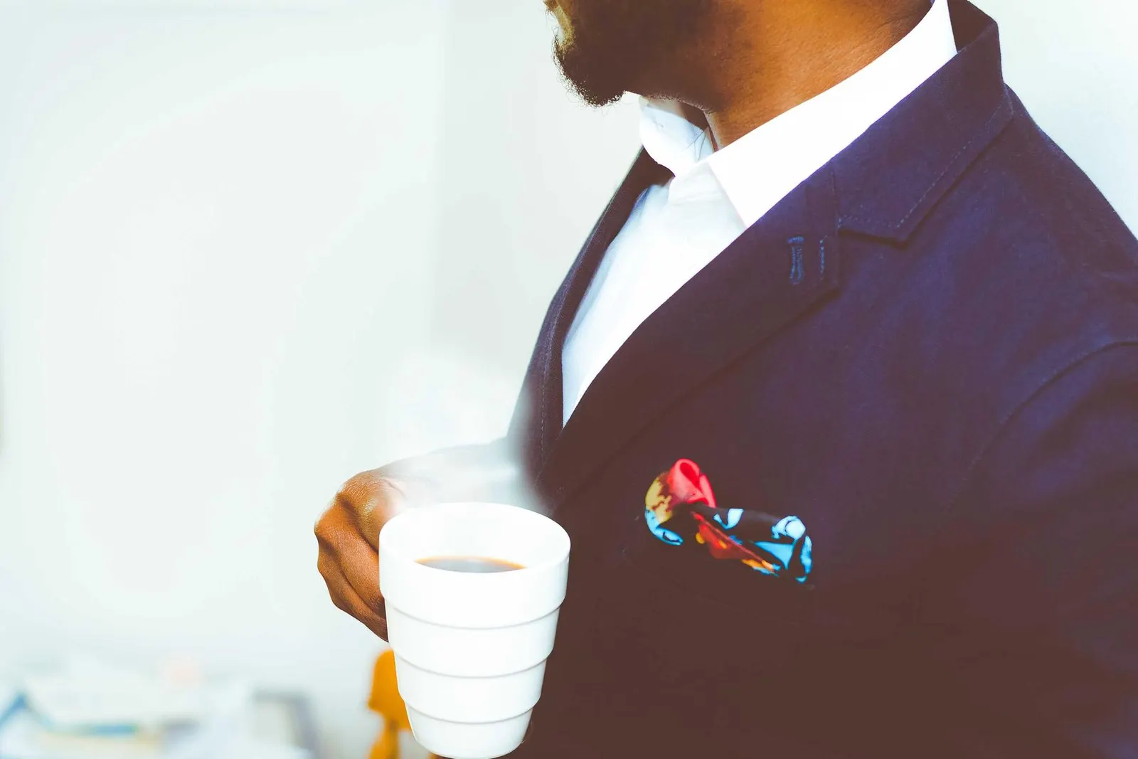 A man in a navy suit with a patterned pocket square